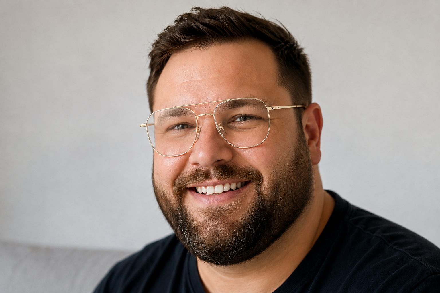 man wearing wide fit gold titanium rectangle glasses
